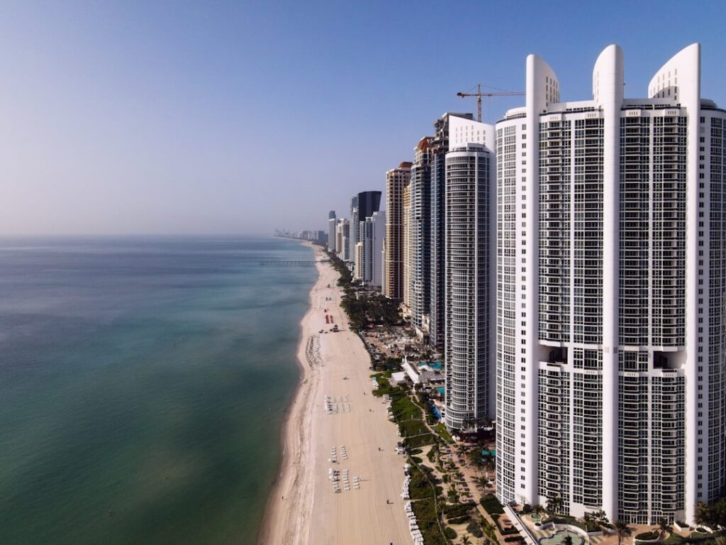 Miami luxury high-rise condo tower under construction with aerial ocean view.