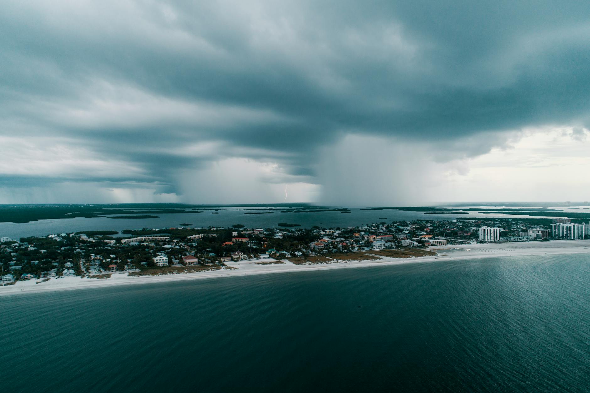 Aerial view of South Florida luxury coastal property with storm clouds on the horizon.