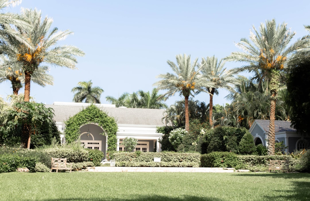 Luxury outdoor living area with pool and tropical landscaping at a South Florida estate.