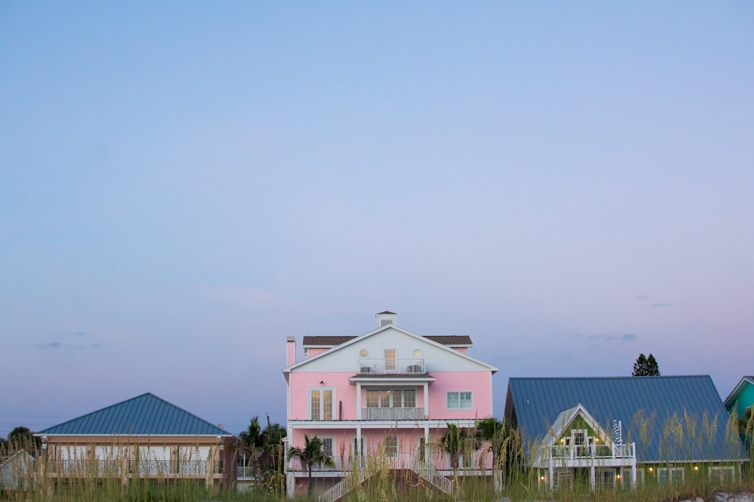 Luxury Florida home exterior at dusk with tropical landscaping and lit pool area.