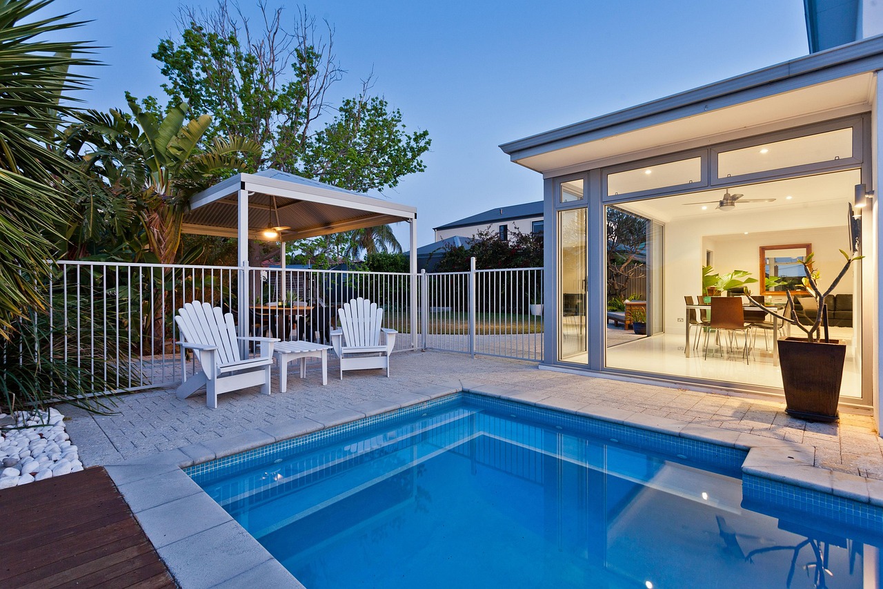 Luxury outdoor living space with pool, lanai, and summer kitchen at a South Florida waterfront estate.