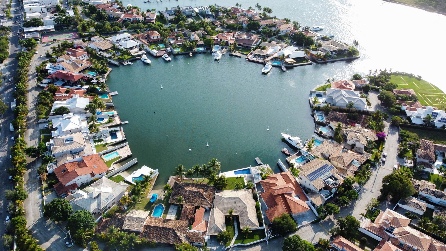 Luxury waterfront estate with pool overlooking South Florida water at sunset.