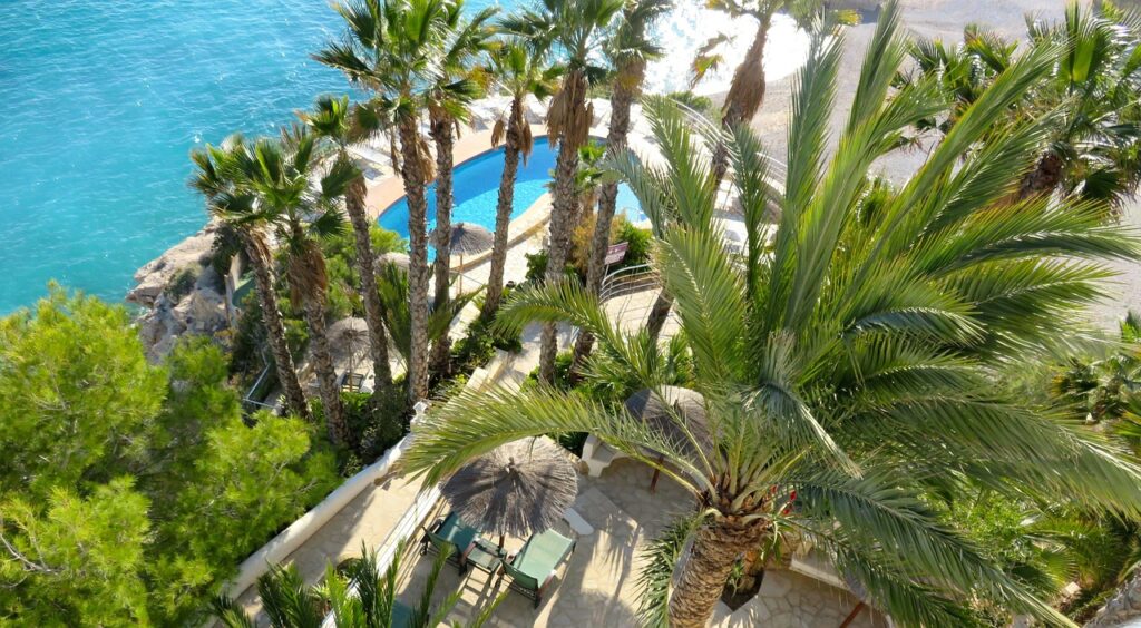 Aerial view of a luxury waterfront estate in South Florida with pool and tropical landscaping.