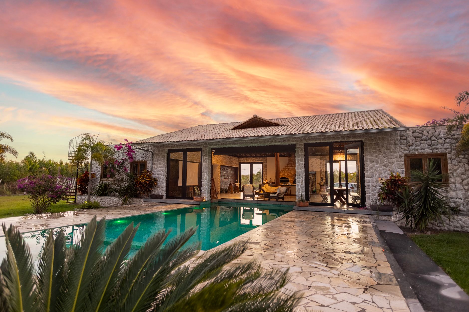Luxury resort-style pool with outdoor kitchen at a South Florida estate.