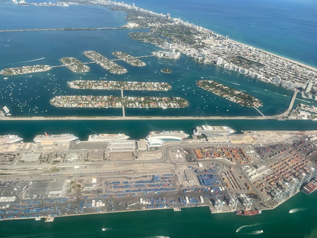 Aerial view of Miami luxury condo towers along the Brickell waterfront with Biscayne Bay in the background.