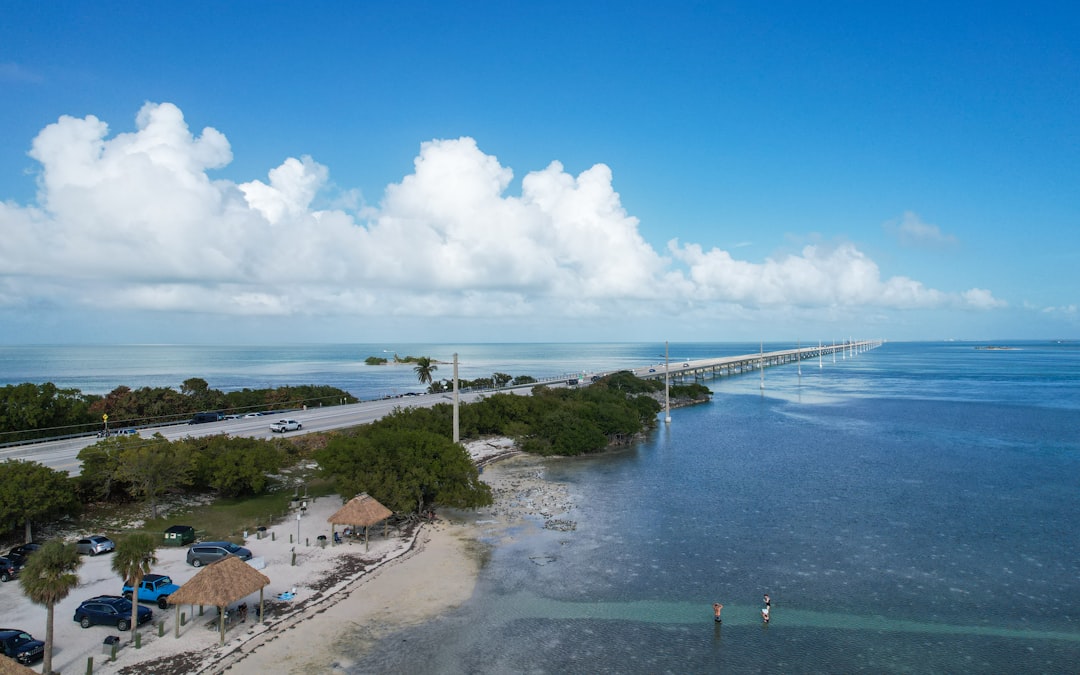 Aerial view of a luxury beach house on Siesta Key, Florida, surrounded by turquoise Gulf water.