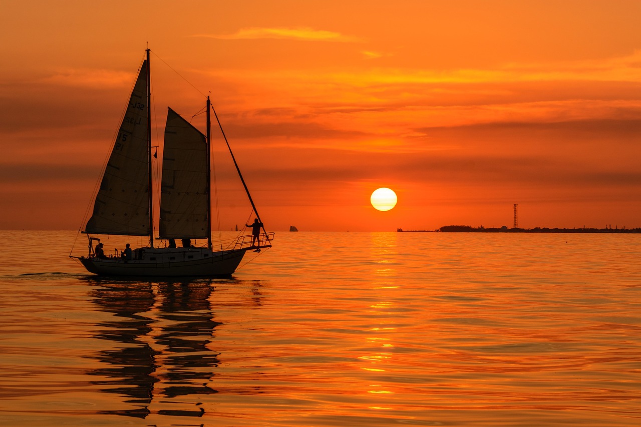 Luxury waterfront estate on Longboat Key, Florida, with a private dock and boat at sunset.