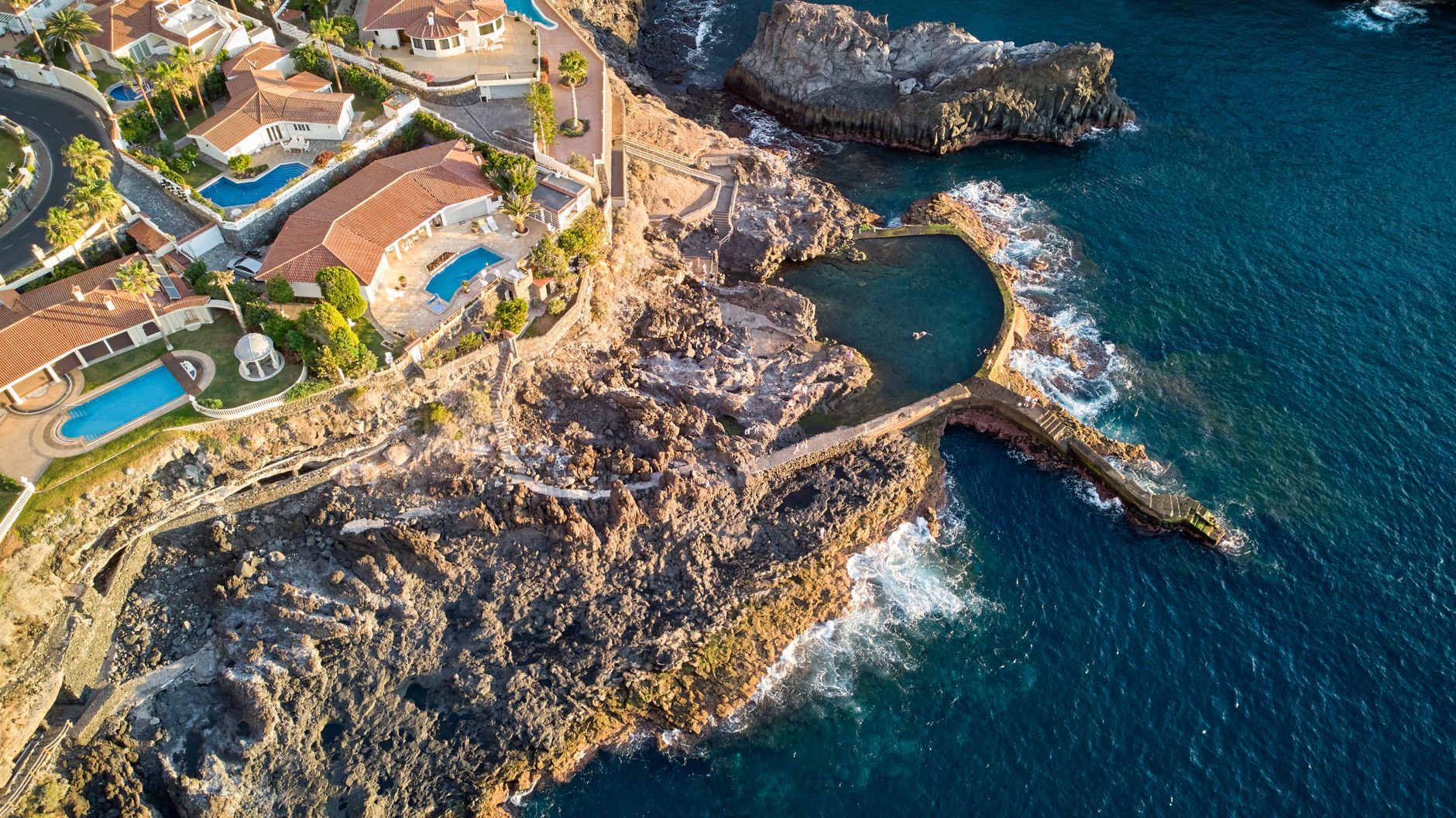 Luxury waterfront estate with pool in South Florida photographed from above at sunset.