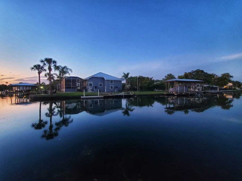 Luxury Florida vacation rental home with pool and waterfront views at sunset.