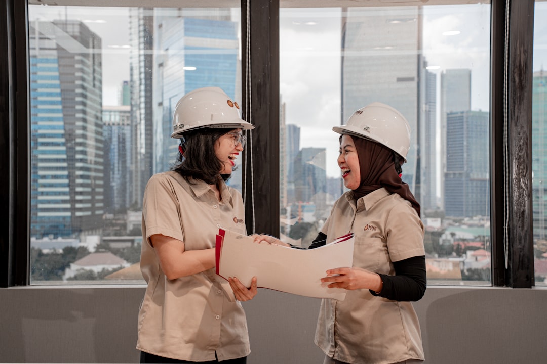 Investor reviewing a pre-construction condo purchase contract and blueprints at a construction site