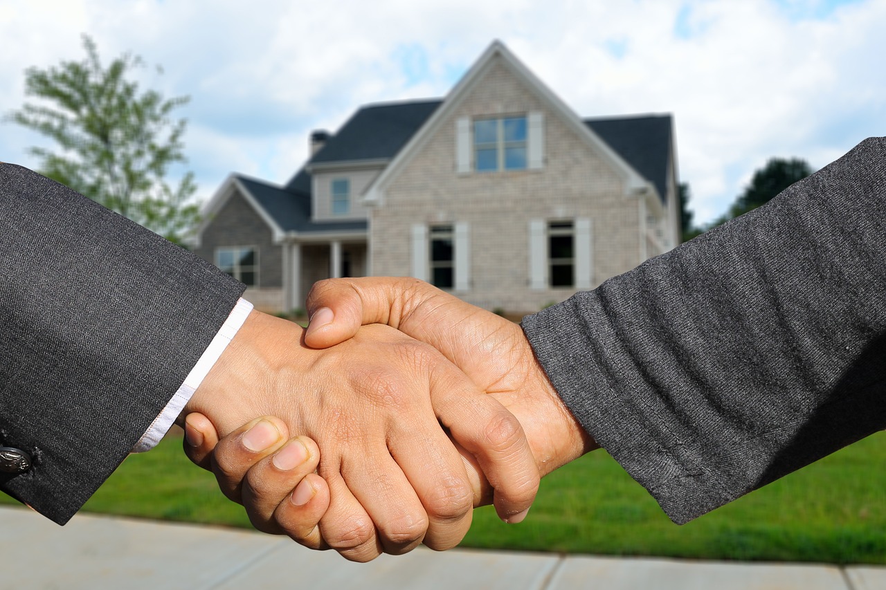 Broker and clients shaking hands after a secure luxury real estate closing in South Florida