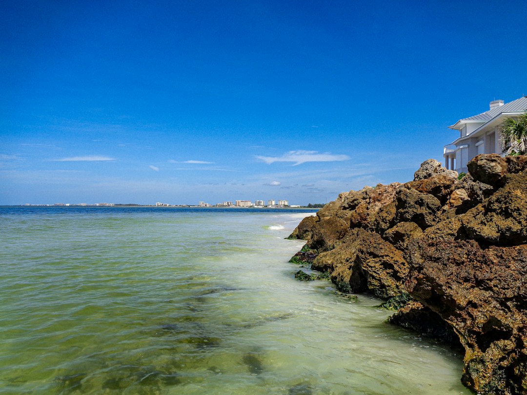 Luxury Florida waterfront home with large impact-rated glass openings facing the water.