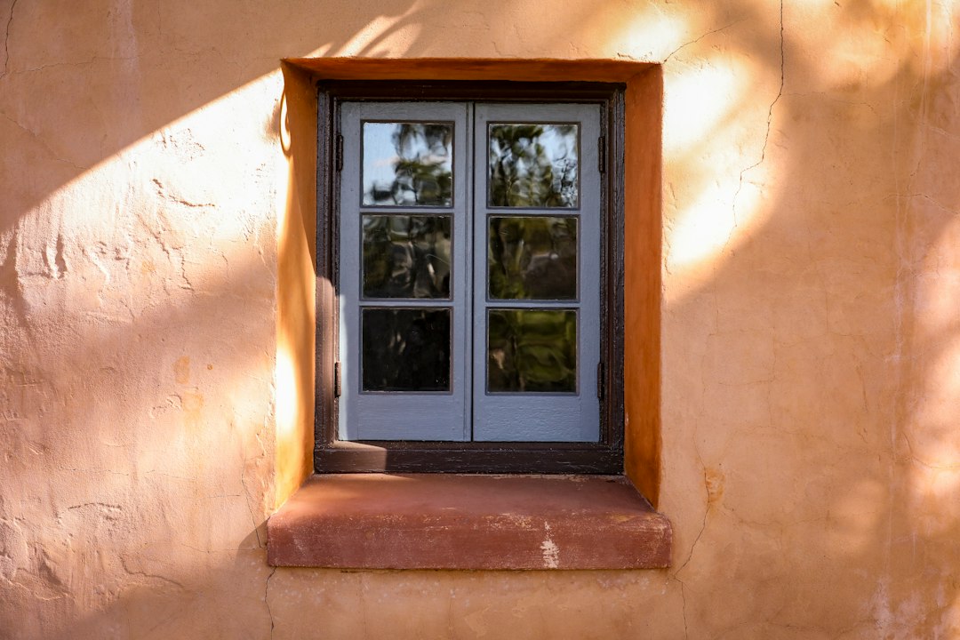 Contractor measuring an opening for impact window installation on a Florida home.