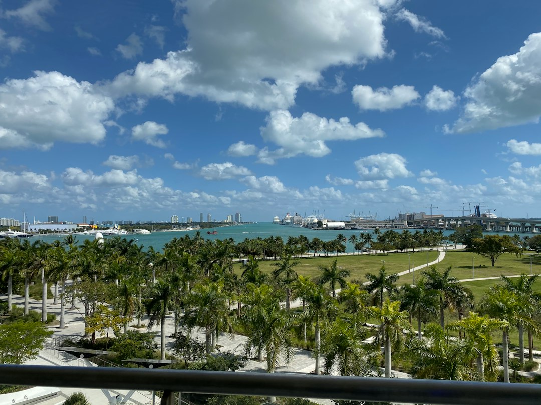 Miami high-rise condo balcony with sliding glass doors overlooking the ocean.